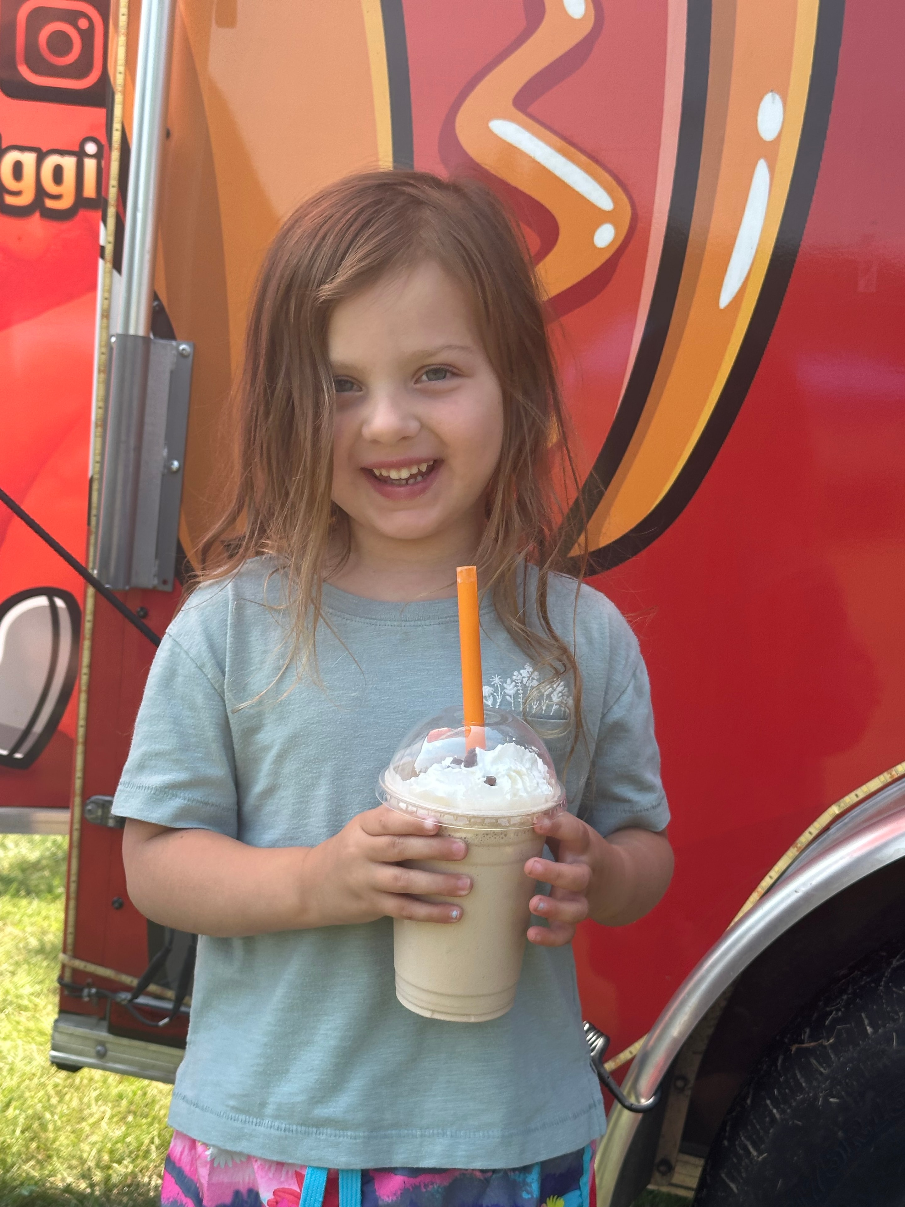 Happy customer enjoying a Hot Diggity milkshake in front of the truck
