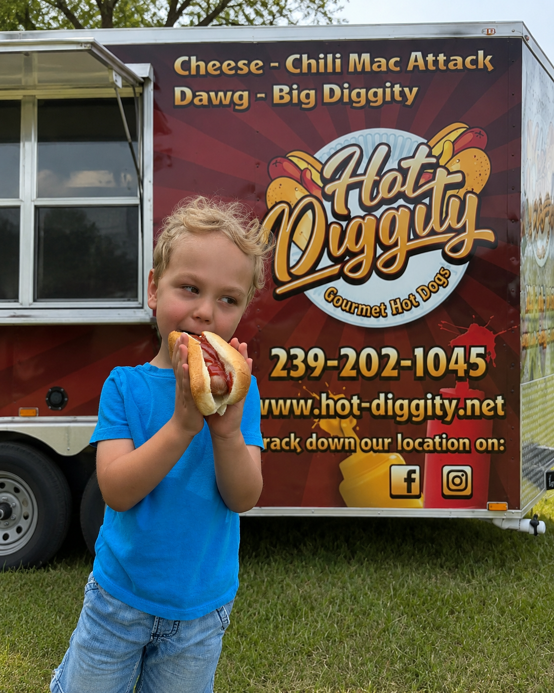 Kid enjoying a hot dog in front of the Hot Diggity food truck